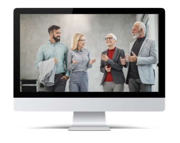 Four professionals engaging in a lively discussion appear on a computer monitor, symbolizing virtual collaboration or an online business meeting.