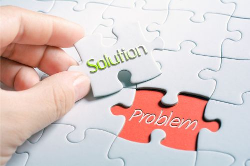 The image features the word "solution" in bold white letters centered on a background of a high-tech computer setup with digital icons representing technology and analytics floating in the foreground. the setting has a blue color theme.